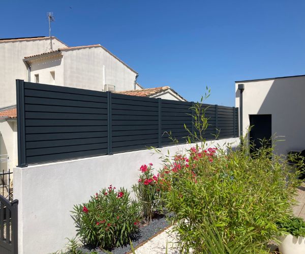 Clôture aluminium persienne installée à Vendres par D.A.M Habitat pour protection au vent