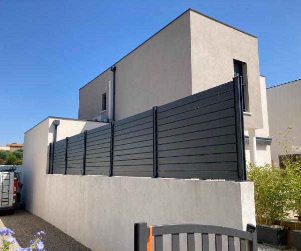 Clôture aluminium persienne montée sur muret dans une maison à Vendres