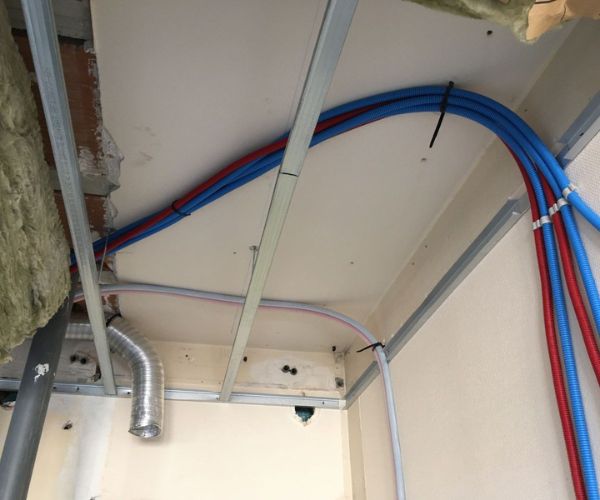 Passage de gaines électriques et VMC dans un faux plafond en cours de rénovation à Béziers