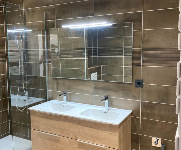 Salle de bain rénovée avec double vasque, carrelage moderne et douche à l’italienne à Béziers
